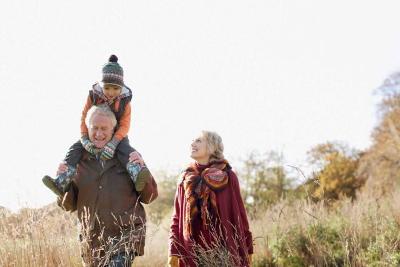 Child and two adults walking in a field