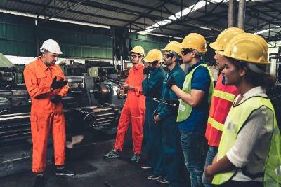 A group of people at work in safety gear and helmets having a briefing