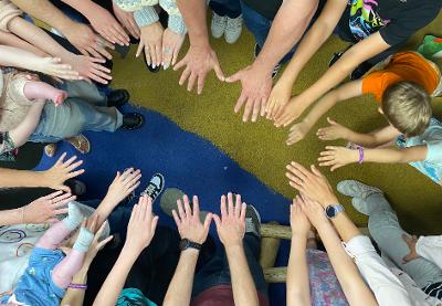 An aerial view of lots of hands coming together, both adult and child. Photographer: Michelle Brady