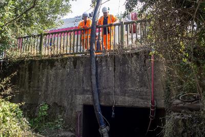 Photograph of Workers with VacEx machine attend to a culvert