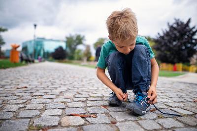 Child tying shoe lace