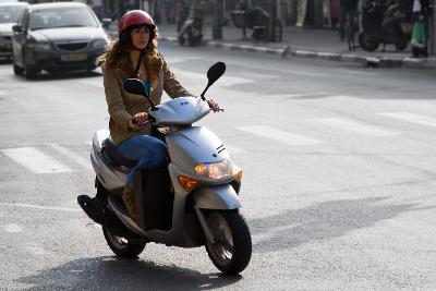 Young girl on a moped scooter